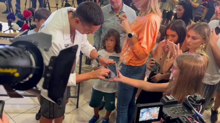 Entuziasm la Otopeni: Micuții s-au înghesuit să-l întâlnească pe David Popovici, care a oferit autografe pe tricouri și telefoane! 1 video copiii au facut coada la otopeni ca sa l vada pe david popovici inotatorul a semnat la revenirea in tara tricouri si telefoane 689049cf78e42